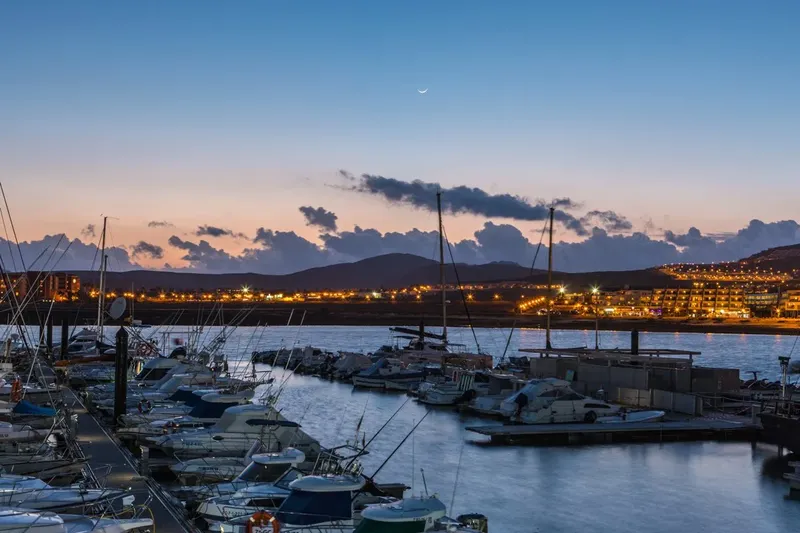 Port de plaisance au crépuscule avec bateaux amarrés et lumières