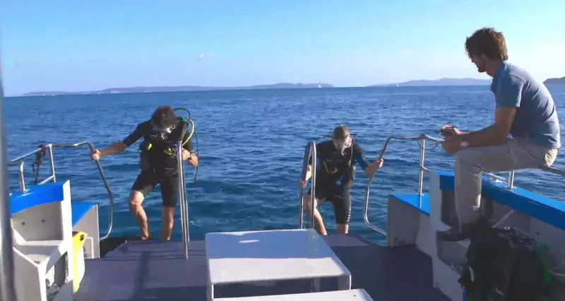 Deux plongeurs s'équipent sur le bateau avant une immersion en mer
