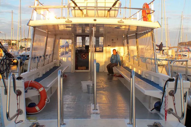 Intérieur d'un bateau de plongée avec une personne assise au repos