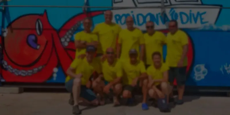 Groupe de personnes souriantes posant devant une fresque colorée