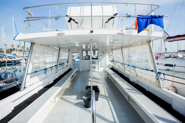 Intérieur d'un bateau de plongée avec des rangées de bouteilles et des sièges