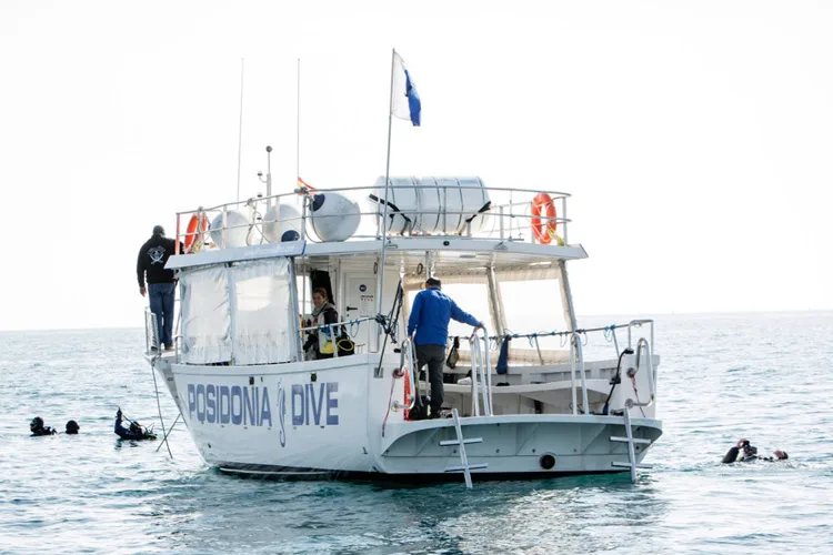 Bateau de plongée avec des plongeurs préparant une sortie en mer