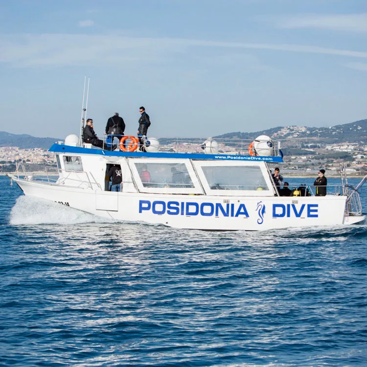 Bateau de plongée blanc avec des personnes à bord en mer