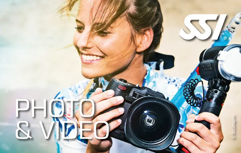 Jeune femme souriante tenant un appareil photo sous-marin