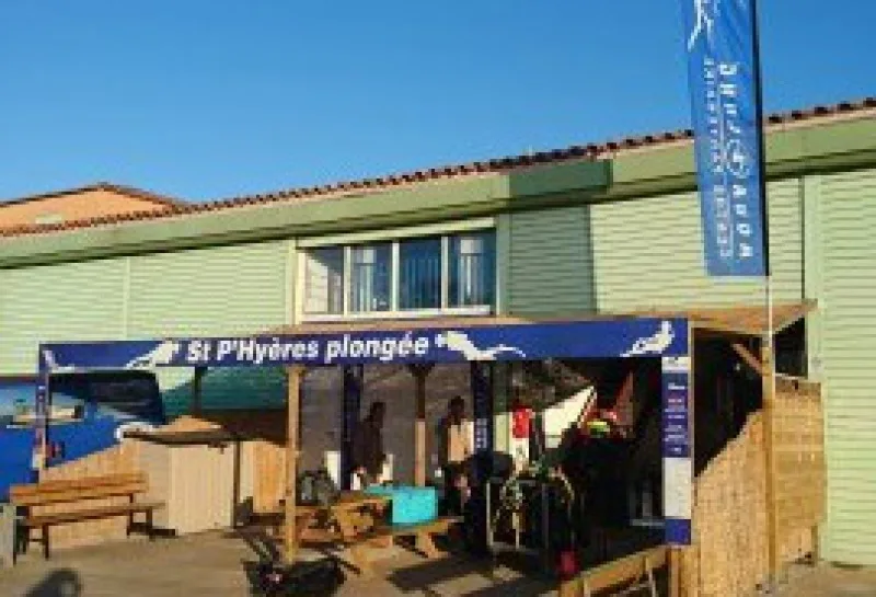 Façade d'un centre de plongée avec des personnes et du matériel