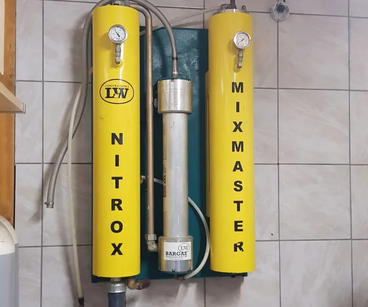 Deux bouteilles de gaz Nitrox et Mixmaster avec manomètres fixés au mur
