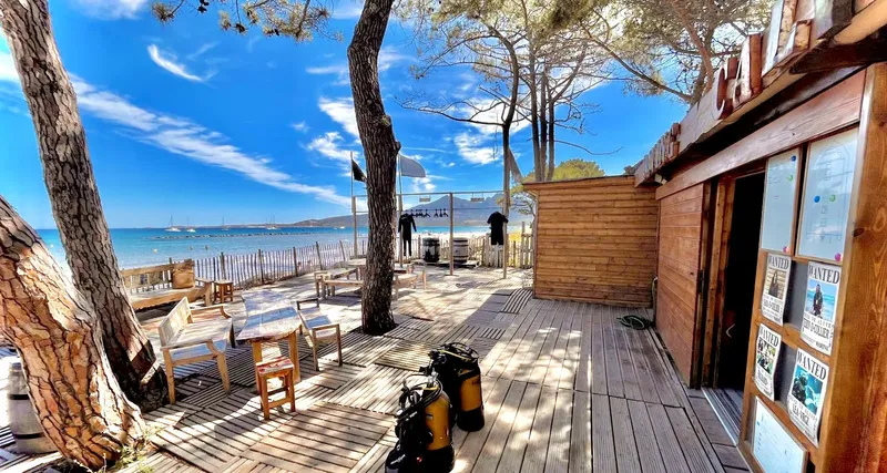 Terrasse en bois avec tables, chaises, bouteilles et affiches Wanted