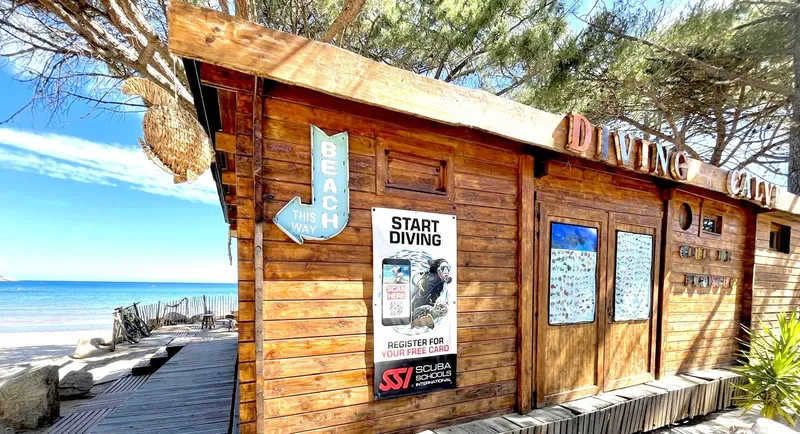 Façade en bois d'un centre de plongée avec signalétique et accès plage