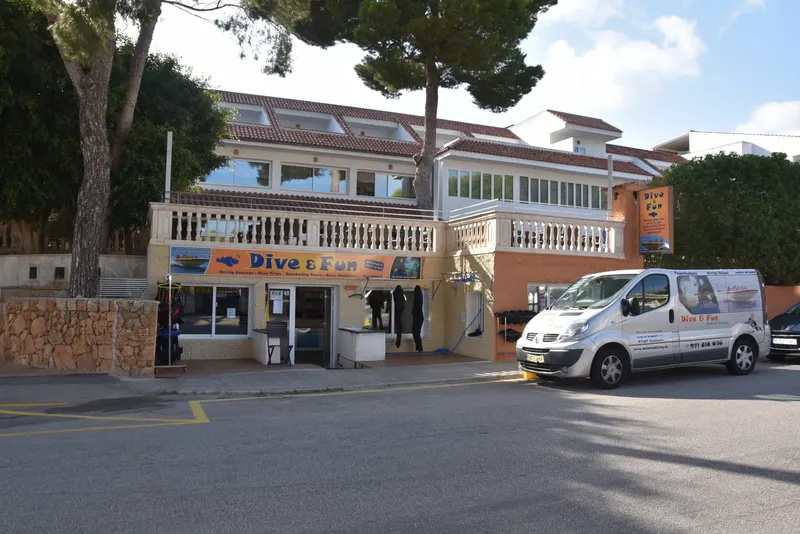 Façade d'un centre de plongée avec van et équipement visible