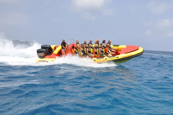 Groupe de personnes en gilets de sauvetage sur un bateau rapide en mer