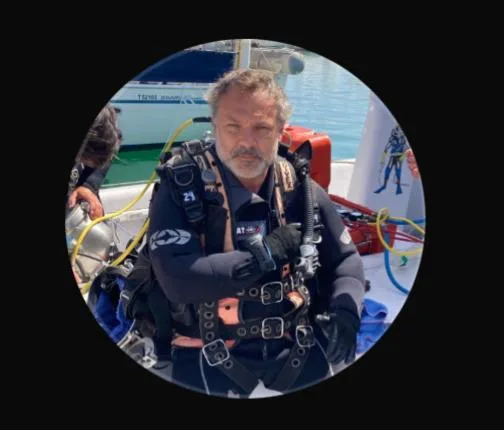 Plongeur équipé sur un bateau avec d'autres plongeurs en arrière-plan