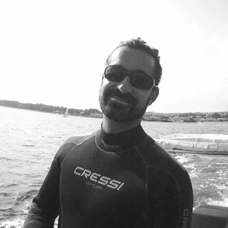 Portrait d'un homme souriant en combinaison de plongée sur un bateau