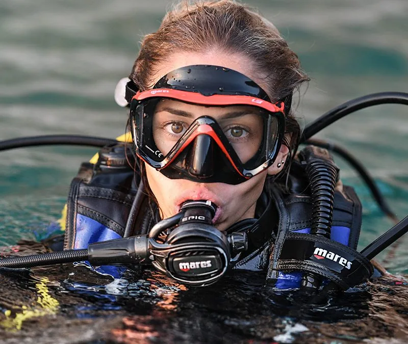 Plongeuse avec masque et détendeur, regardant vers l'avant sous l'eau