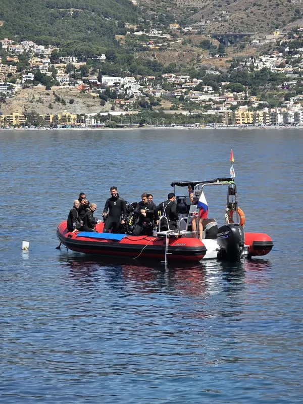 Plongeurs à bord d'un semi-rigide sur une mer calme ensoleillée
