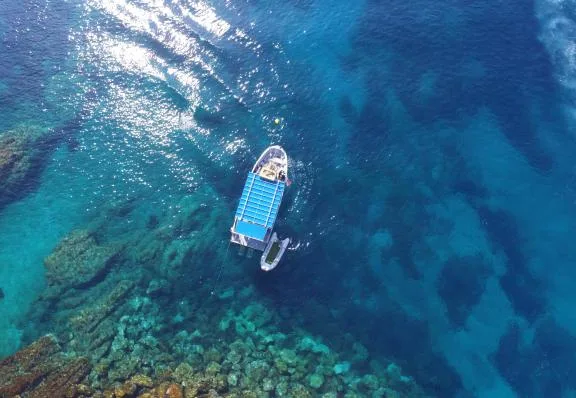 Vue aérienne d'un bateau de plongée sur une eau turquoise claire