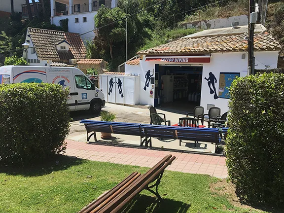 Façade d'un centre de plongée avec bouteilles et espace détente extérieur