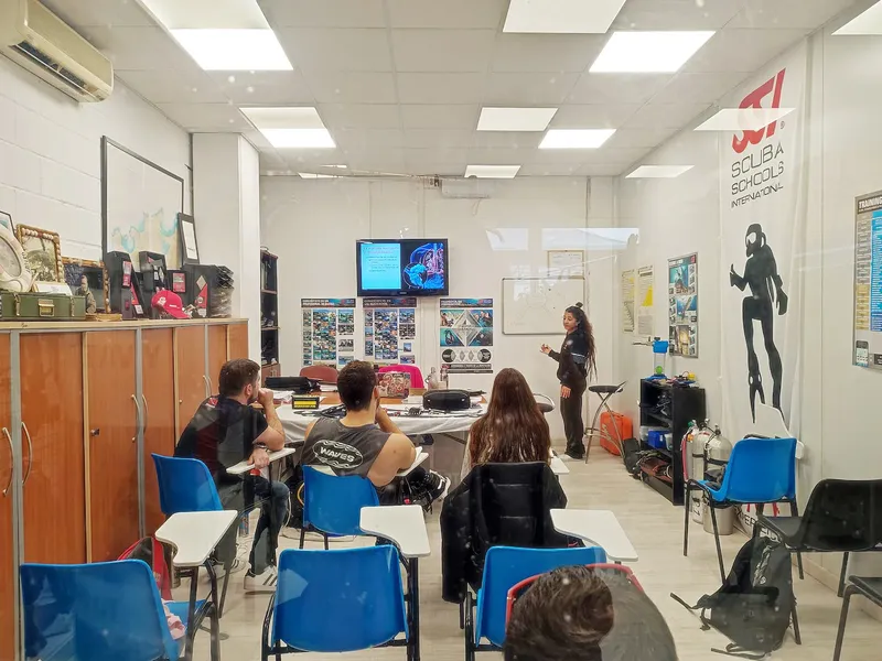 Salle de cours de plongée avec instructeur et élèves attentifs