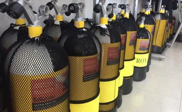 Rangée de bouteilles de plongée avec détendeurs et protections