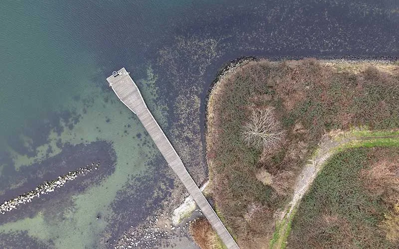 Vue aérienne d'un ponton en bois s'avançant dans l'eau turquoise