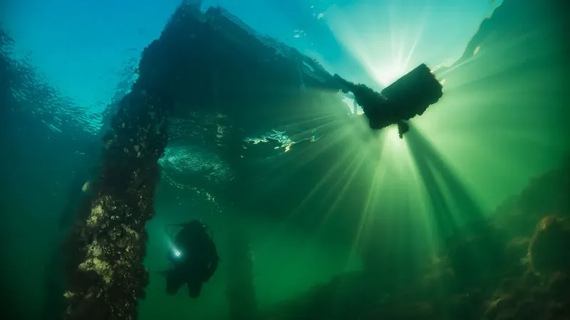 Plongeur explorant l'épave d'un navire sous l'eau, lumière divine