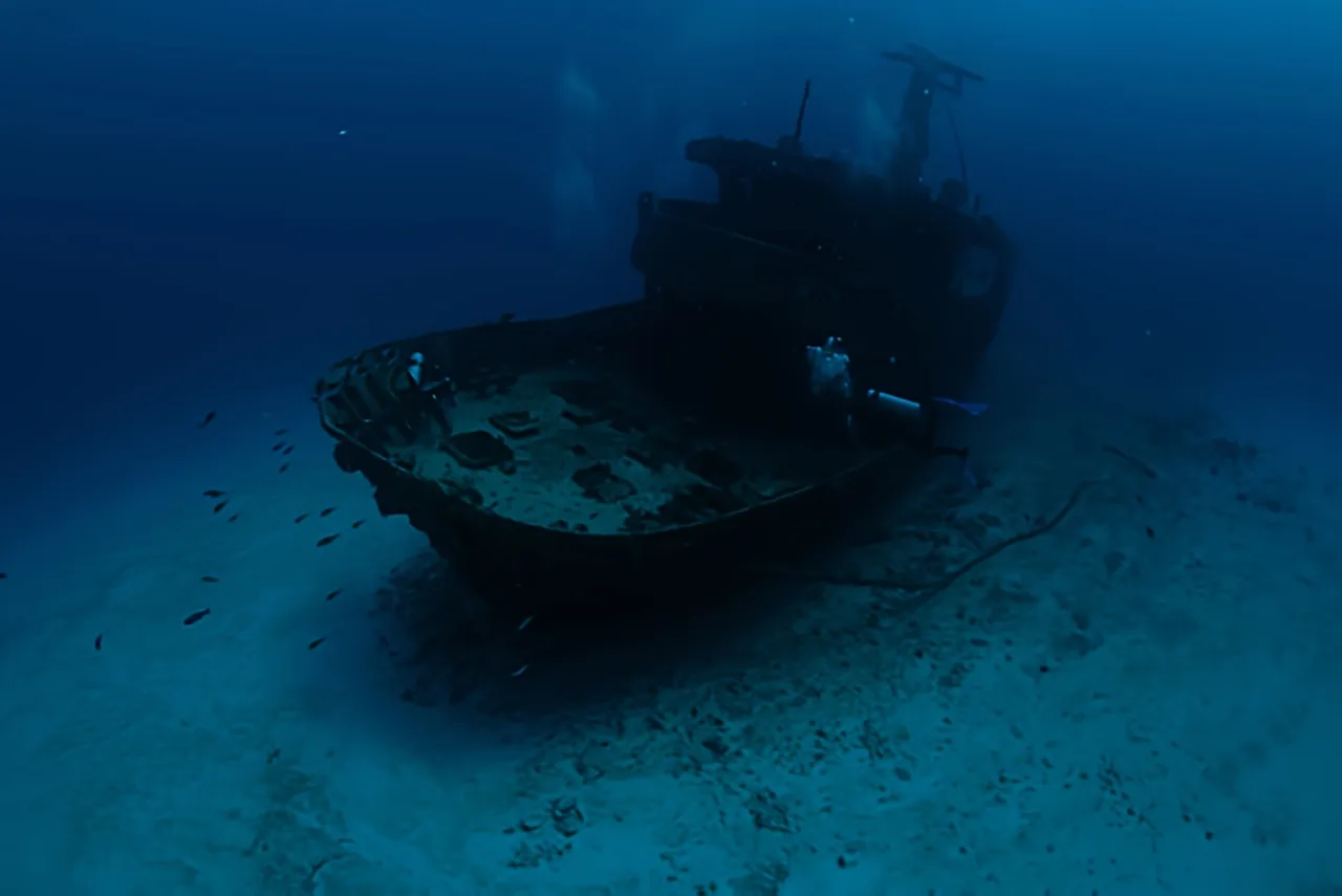 Épave de bateau coulé, fond marin sablonneux, lumière bleutée