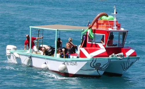 Bateau de plongée coloré avec des plongeurs à bord en mer