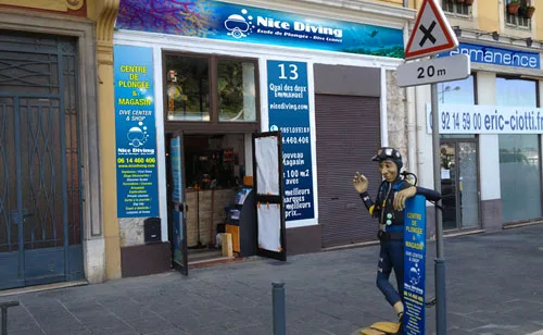 Façade d'un centre de plongée avec manequin plongeur et signalisation