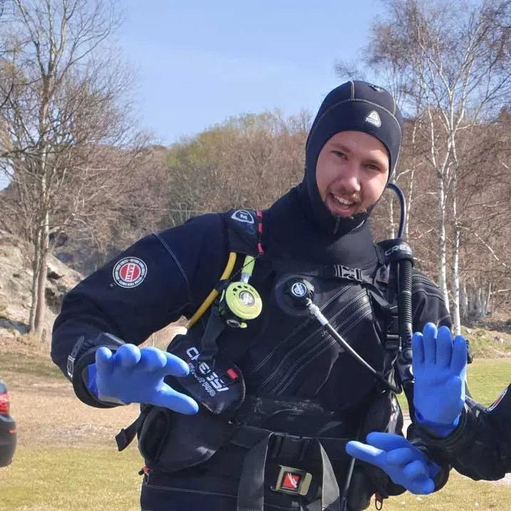 Plongeur souriant équipé d'un gilet et d'un détendeur bleu