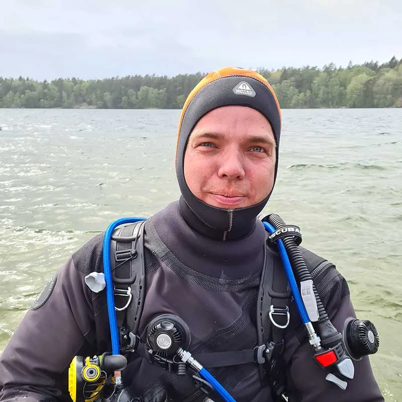 Plongeur souriant équipé de son matériel de plongée en surface
