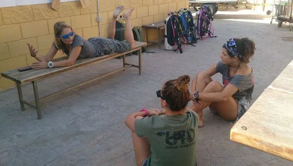 Trois femmes discutent et se reposent près de l'équipement de plongée
