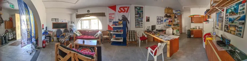 Intérieur d'un centre de plongée avec du matériel, des affiches et mobilier