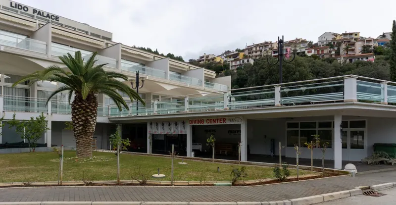 Façade d'un centre de plongée avec un bâtiment blanc et des palmiers