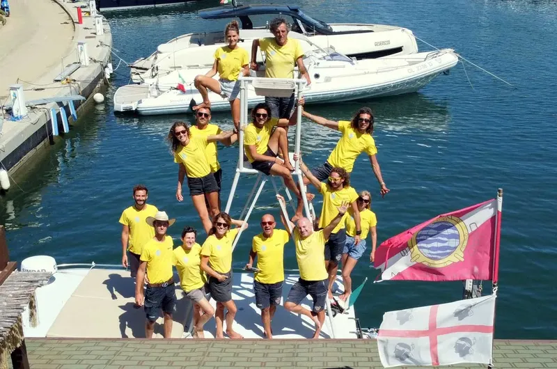 Groupe de personnes souriantes en t-shirts jaunes sur un ponton