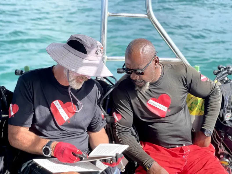 Deux hommes discutent d'une carte de plongée à bord d'un bateau