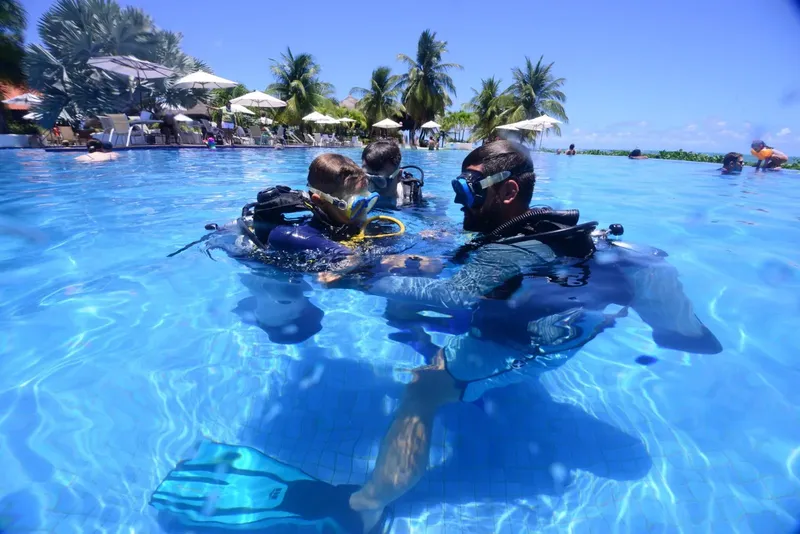 Deux plongeurs en formation dans une piscine, équipement complet visible