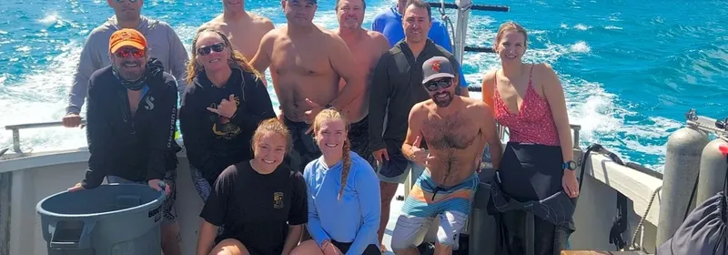 Groupe de plongeurs souriants à bord d'un bateau en mer