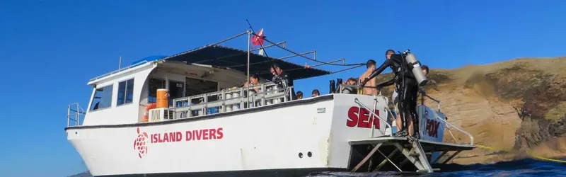 Bateau de plongée avec des plongeurs préparant leur matériel en mer