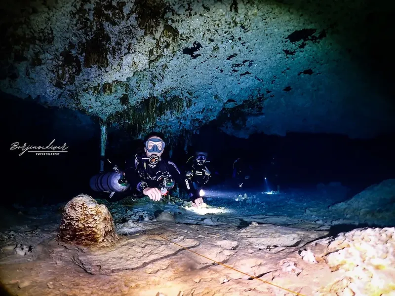 Deux plongeurs explorent une grotte sous-marine éclairée par des lampes