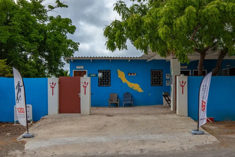 Façade d'un bâtiment bleu avec des drapeaux et une carte de l'île