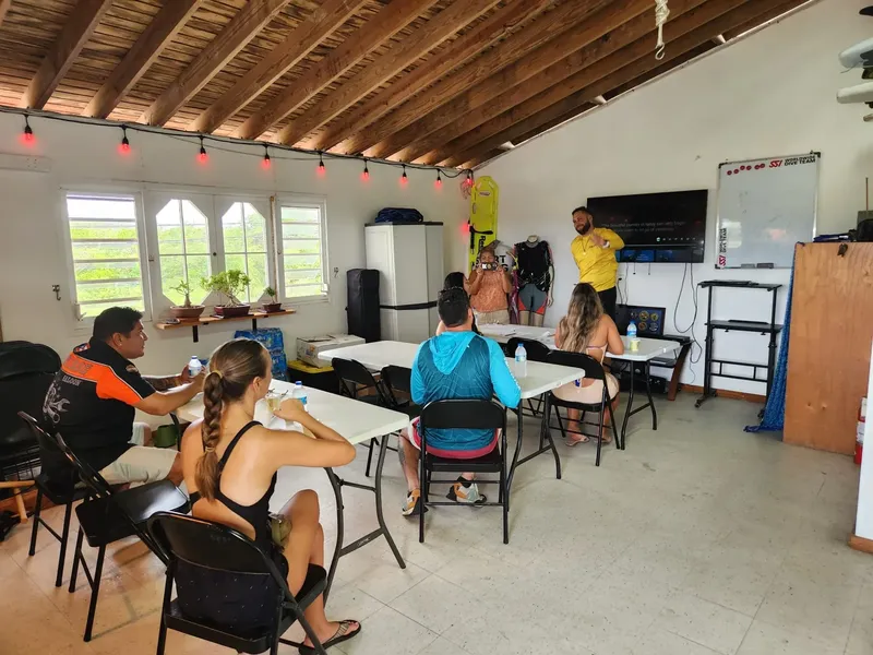 Cours de plongée en salle avec instructeur et participants attentifs