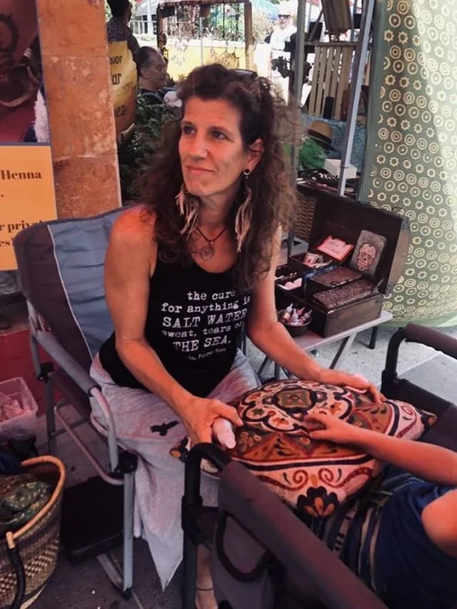 Femme assise sur un coussin, regardant vers l'avant, en extérieur