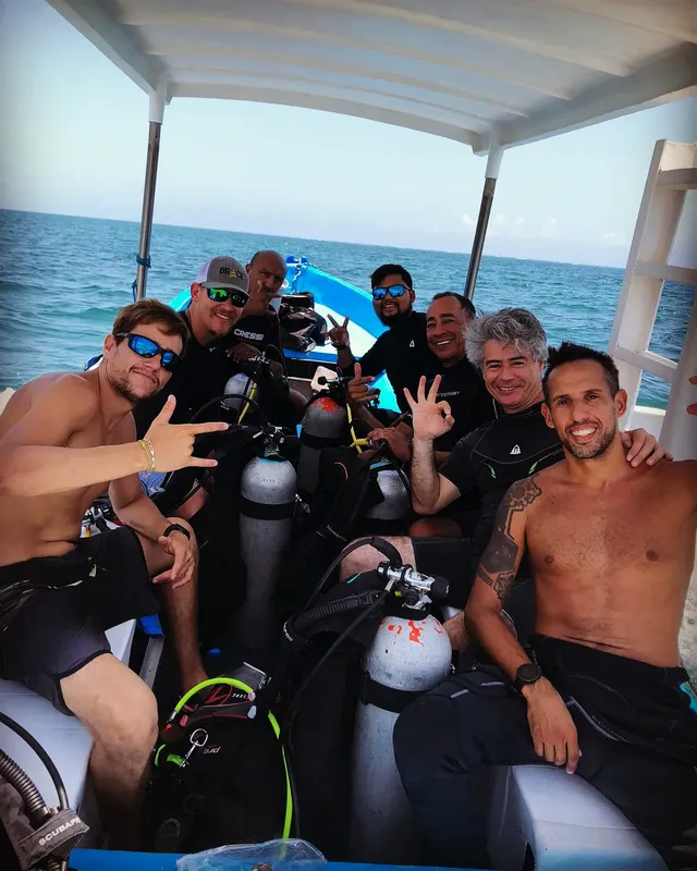 Groupe de plongeurs souriants à bord d'un bateau en mer
