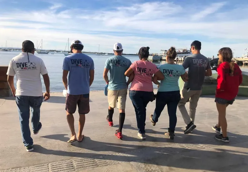 Groupe de personnes marchant vers le port avec des t-shirts