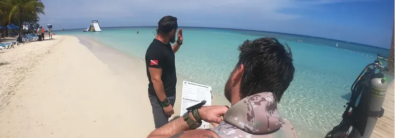 Deux hommes sur une plage, un donne des instructions de plongée