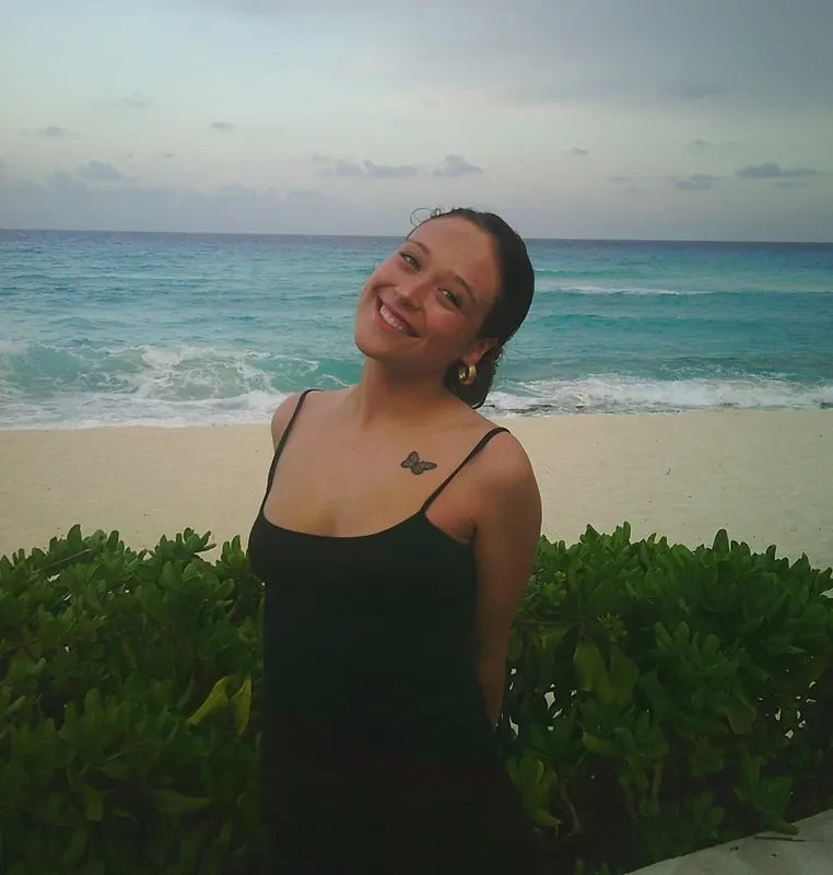 Jeune femme souriante sur une plage de sable blanc turquoise