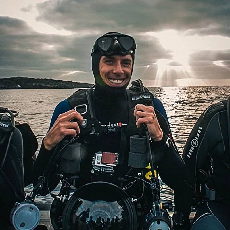 Plongeur souriant en combinaison, prêt à plonger en mer