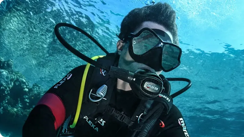 Plongeur avec masque et détendeur, regardant vers l'avant dans l'eau