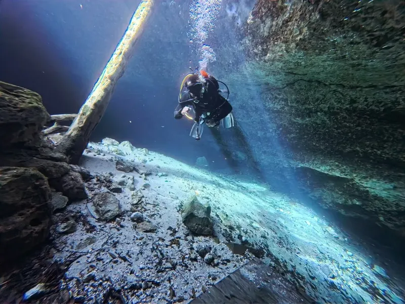 Plongeur explorant une grotte sous-marine avec une visibilité claire