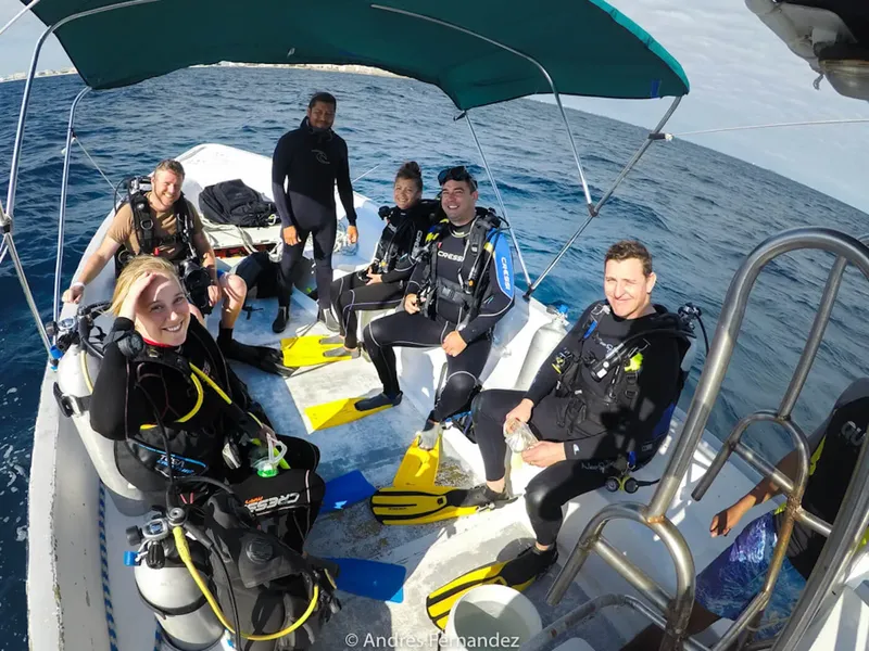 Groupe de plongeurs souriants à bord d'un bateau pneumatique en mer