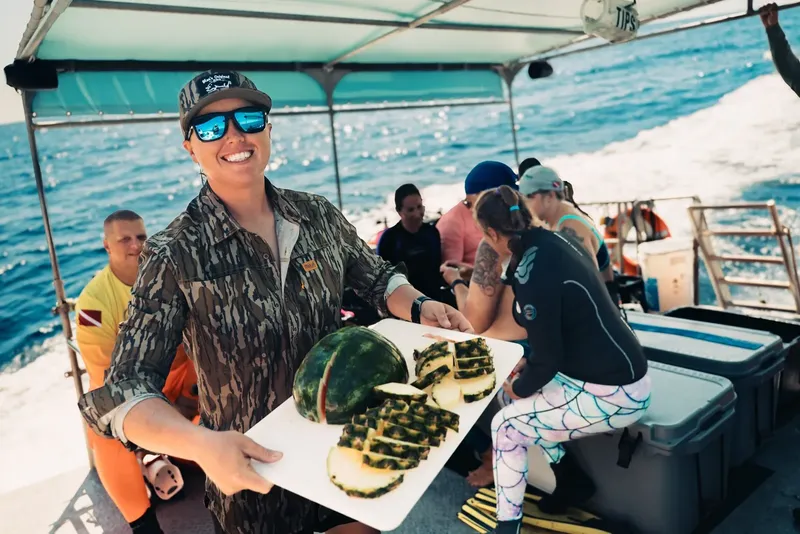Personnes sur un bateau de plongée avec des fruits frais coupés